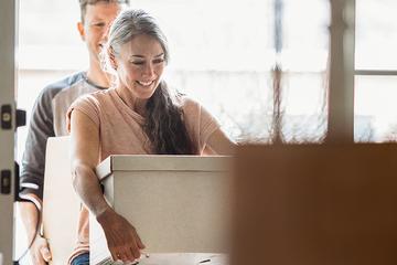 Person smiling carrying a box